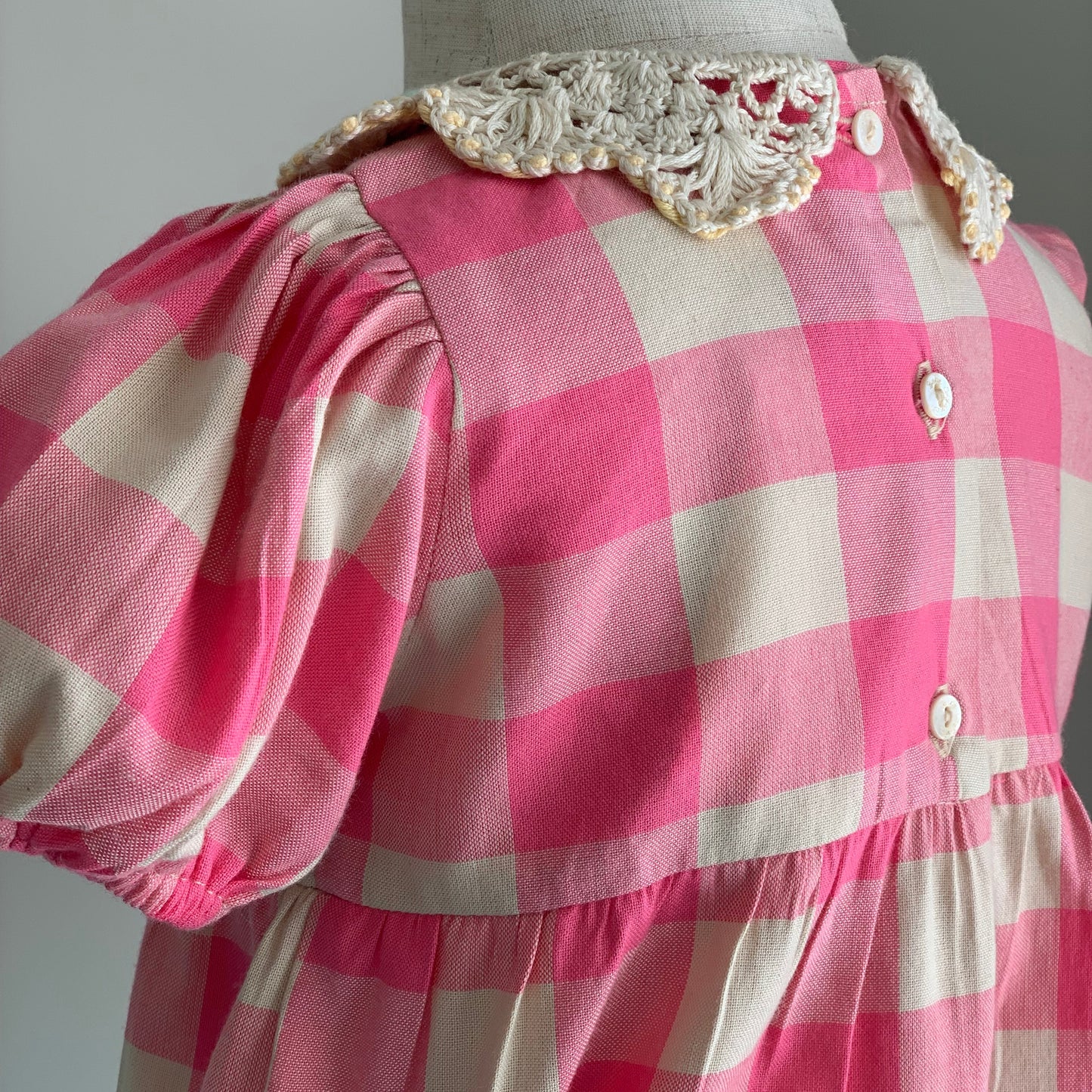 Anais Romper on mannequin close up, , baby girl cotton pink check romper, crotched collar, back view button detail — Willowby, sizes 6–18 months