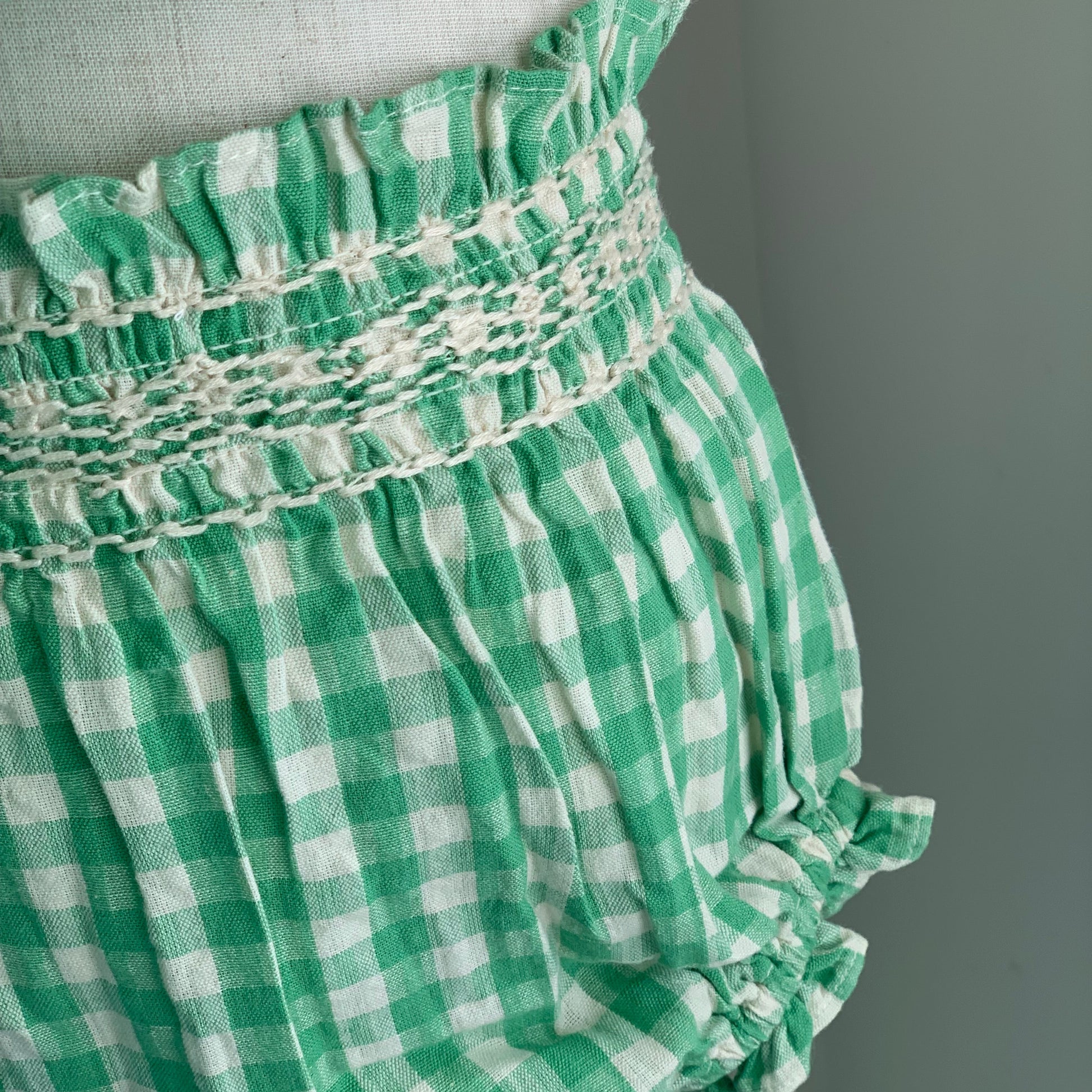 Tilia Bloomers on mannequin, close up, Green check cotton bloomers, smocking detail - Willowby.  